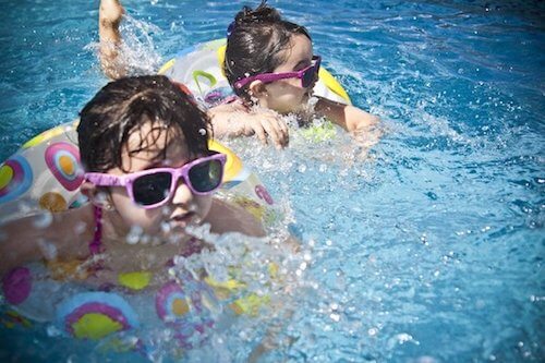 Kinder planschen im Schwimmbad und tragen Ohrstöpsel von BOLLSEN Gehörschutz